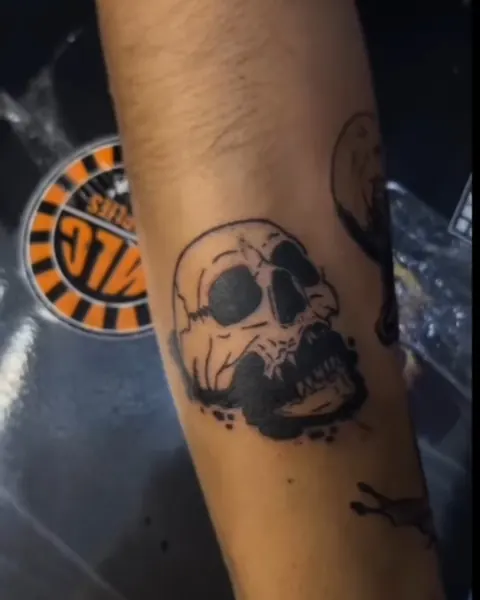 Blackwork skull tattoo on a forearm
